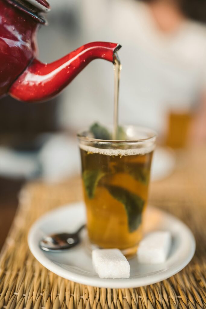 outdoor-image-02 Close-up of Moroccan mint tea served with sugar cubes on a saucer.