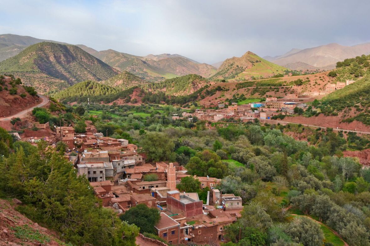 Tours Scenic aerial view of Ait Barka village amidst lush green valleys and rugged mountains.